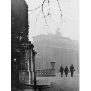  Three Men Walk Towards the Brandenburg Gate on a Foggy Day 